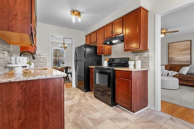 kitchen with decorative backsplash, light stone countertops, a textured ceiling, ceiling fan with notable chandelier, and black appliances