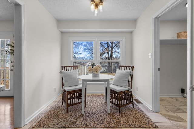 sitting room featuring a textured ceiling, breakfast area, and light tile patterned flooring