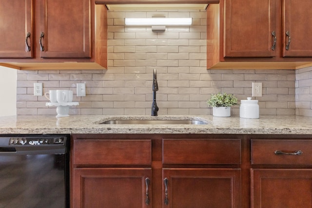 kitchen with light stone countertops, backsplash, dishwasher, and sink