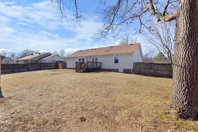 rear view of house featuring a wooden deck and a lawn