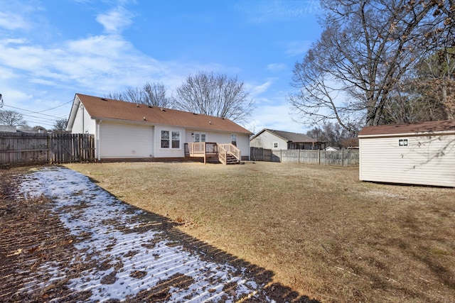 back of property featuring a yard, a deck, and a storage shed