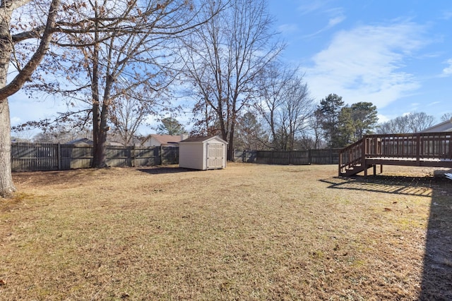 view of yard with a wooden deck and a storage unit