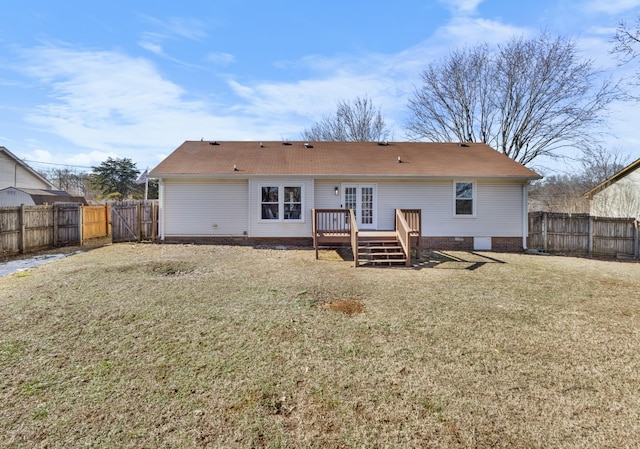 rear view of house featuring a lawn and a wooden deck