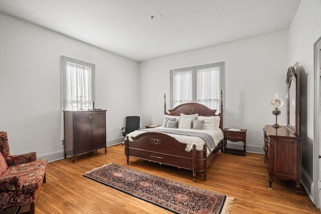 bedroom with wood-type flooring and multiple windows