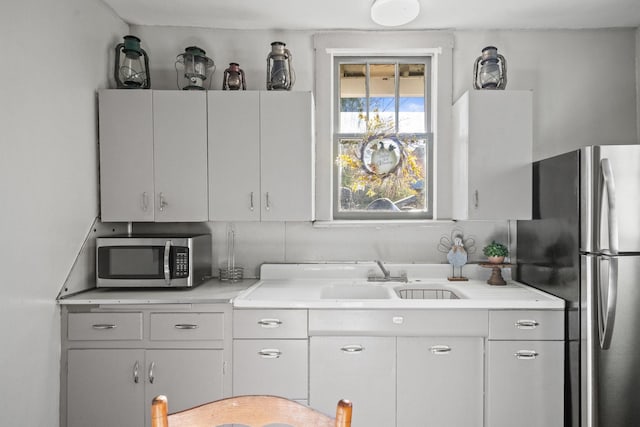 kitchen featuring appliances with stainless steel finishes, white cabinets, and sink