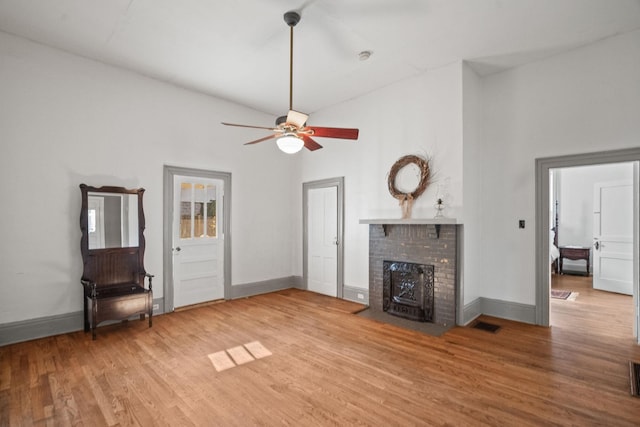 unfurnished living room featuring ceiling fan, wood-type flooring, and vaulted ceiling