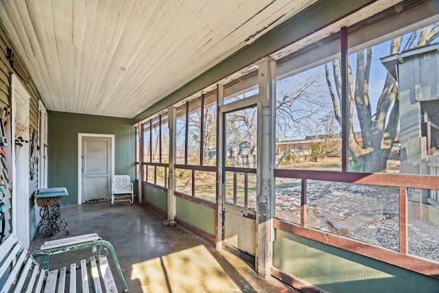 sunroom featuring wood ceiling and a healthy amount of sunlight