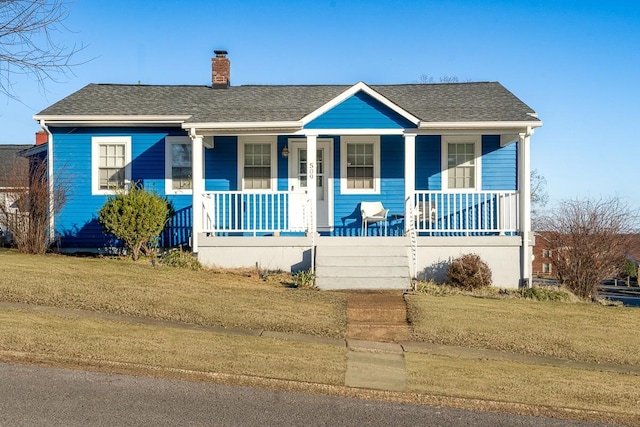 bungalow-style house with covered porch and a front lawn