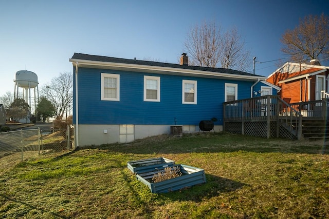 rear view of house featuring a wooden deck, cooling unit, and a yard