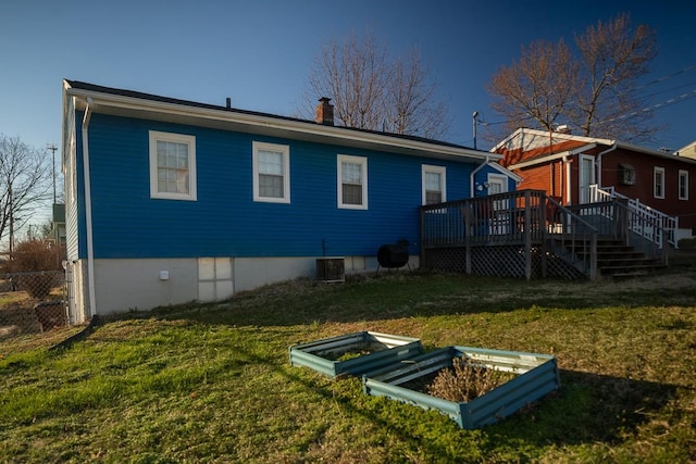 back of house featuring a lawn, central air condition unit, and a wooden deck