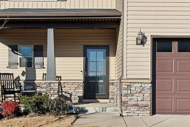 entrance to property featuring covered porch and a garage