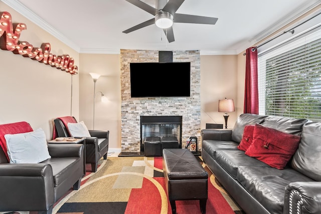 living room featuring ceiling fan, ornamental molding, and a stone fireplace