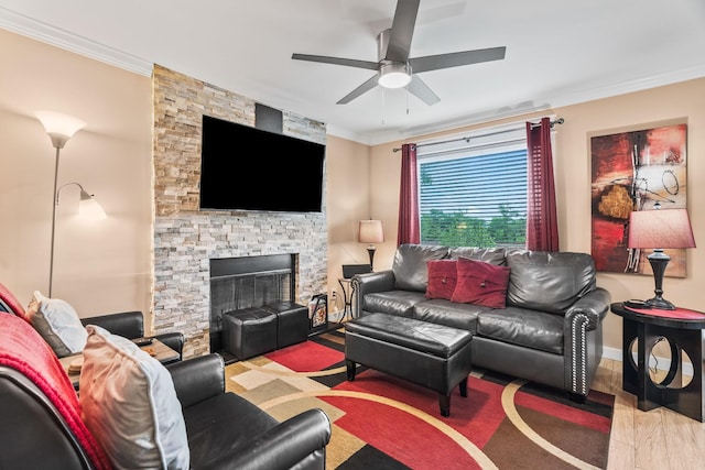 living room featuring ceiling fan, crown molding, hardwood / wood-style flooring, and a stone fireplace