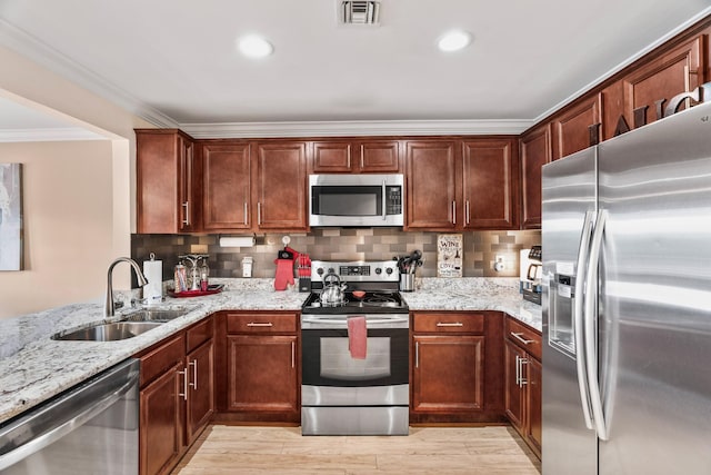 kitchen featuring sink, light hardwood / wood-style flooring, light stone countertops, ornamental molding, and stainless steel appliances