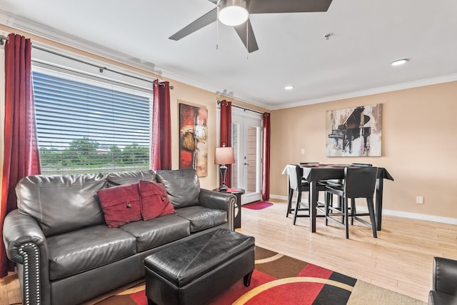 living room with ceiling fan, ornamental molding, and light hardwood / wood-style floors