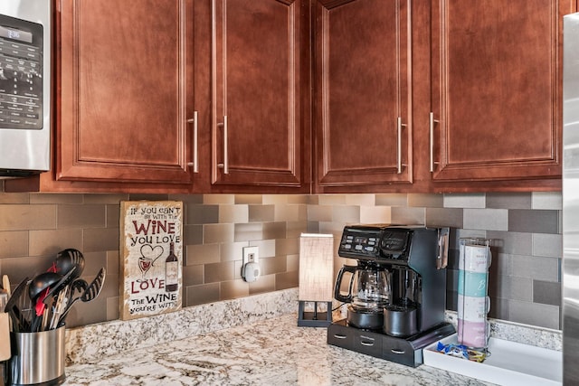 kitchen with decorative backsplash and light stone counters