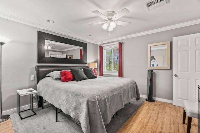 bedroom featuring ceiling fan, ornamental molding, and hardwood / wood-style floors