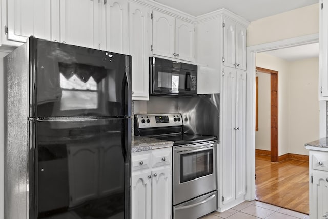 kitchen featuring light tile patterned flooring, white cabinets, and black appliances