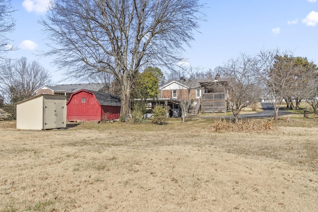 view of yard featuring a deck and a storage unit