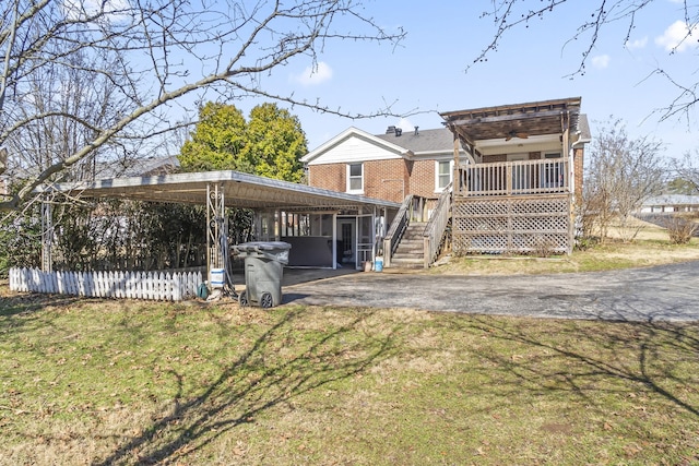 rear view of house featuring a carport, a yard, and covered porch