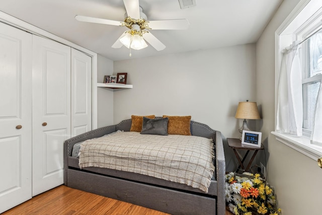 bedroom featuring ceiling fan, a closet, and hardwood / wood-style floors