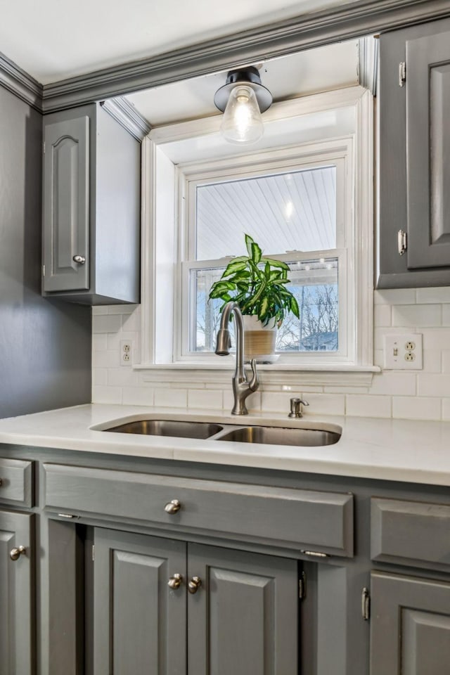 kitchen featuring sink, gray cabinetry, and tasteful backsplash