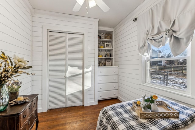 bedroom with ceiling fan, a closet, dark hardwood / wood-style flooring, and ornamental molding