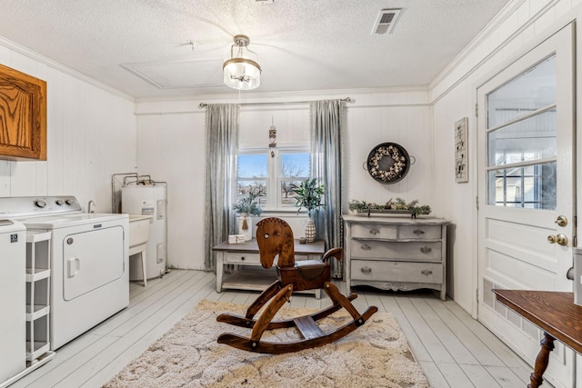 laundry area with separate washer and dryer, a textured ceiling, electric water heater, and ornamental molding