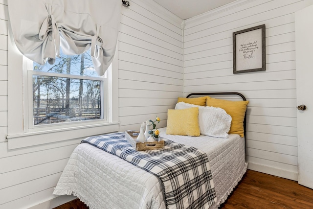 bedroom with dark hardwood / wood-style floors and wooden walls