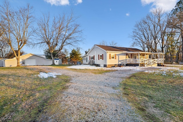 exterior space featuring a garage, an outbuilding, and a porch