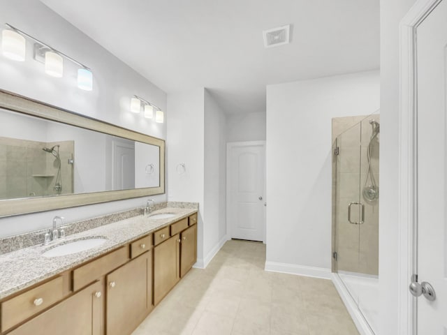 bathroom with an enclosed shower, vanity, and tile patterned flooring