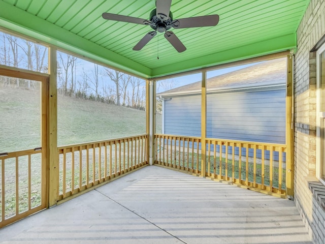 unfurnished sunroom featuring ceiling fan