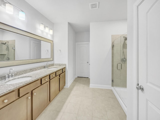 bathroom featuring tile patterned floors, a shower with door, and vanity