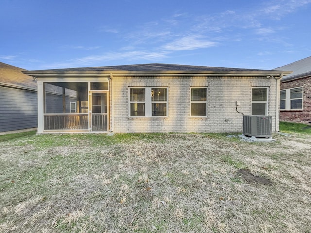 rear view of property with a sunroom, a lawn, and central air condition unit