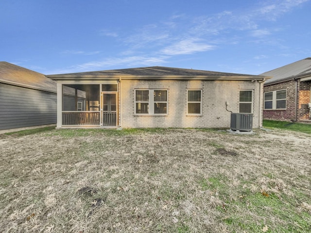 back of property with central AC and a sunroom