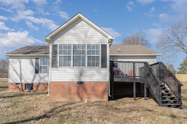 back of house with a wooden deck and a lawn