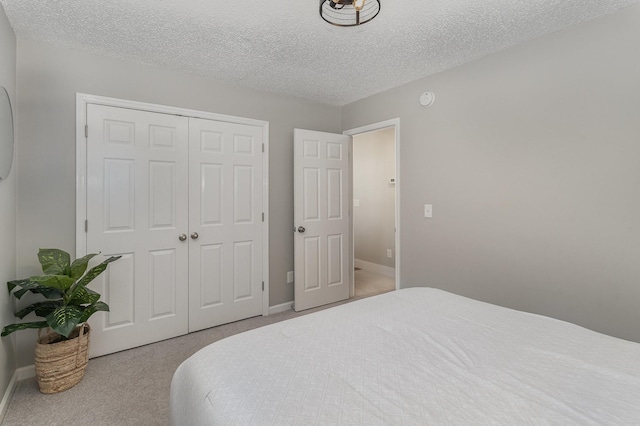 bedroom featuring carpet floors, a textured ceiling, and a closet