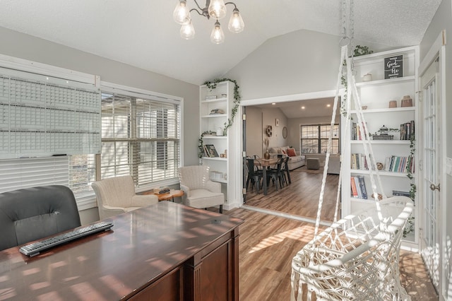 office with lofted ceiling, light wood-type flooring, an inviting chandelier, and a textured ceiling