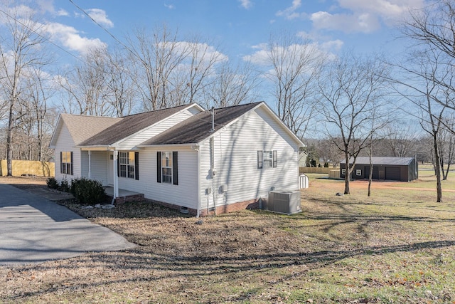 view of home's exterior with a garage, central AC, a lawn, and an outdoor structure