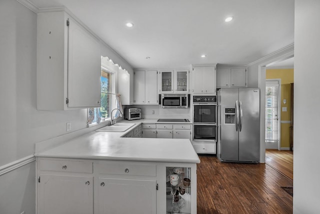 kitchen with white cabinetry, kitchen peninsula, dark hardwood / wood-style flooring, black appliances, and sink