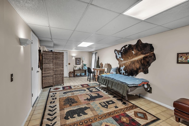 tiled bedroom featuring a paneled ceiling