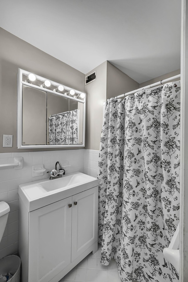 bathroom with tile walls and vanity