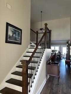 stairway with ceiling fan and hardwood / wood-style flooring