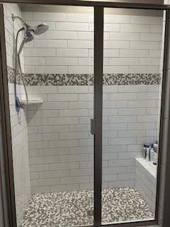 bathroom with a shower with door