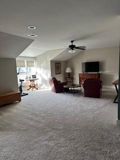 carpeted living room with ceiling fan and vaulted ceiling