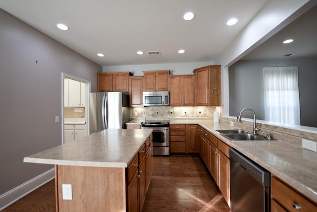 kitchen featuring sink, stainless steel appliances, a center island, dark hardwood / wood-style flooring, and decorative backsplash