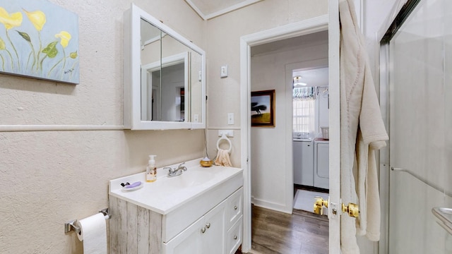 bathroom with hardwood / wood-style floors, vanity, and independent washer and dryer