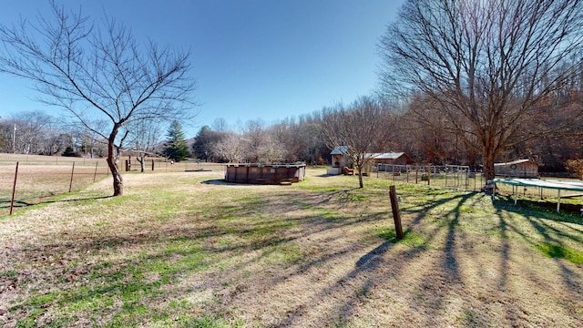 view of yard featuring a trampoline and a rural view