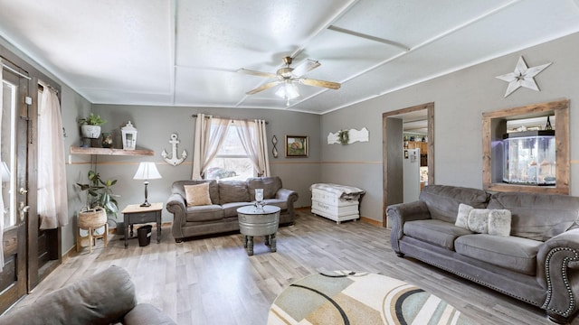 living room featuring ceiling fan, lofted ceiling, and light hardwood / wood-style floors