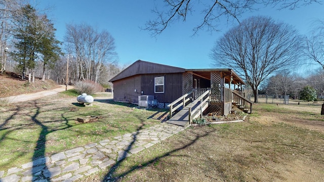 view of home's exterior with cooling unit and a lawn